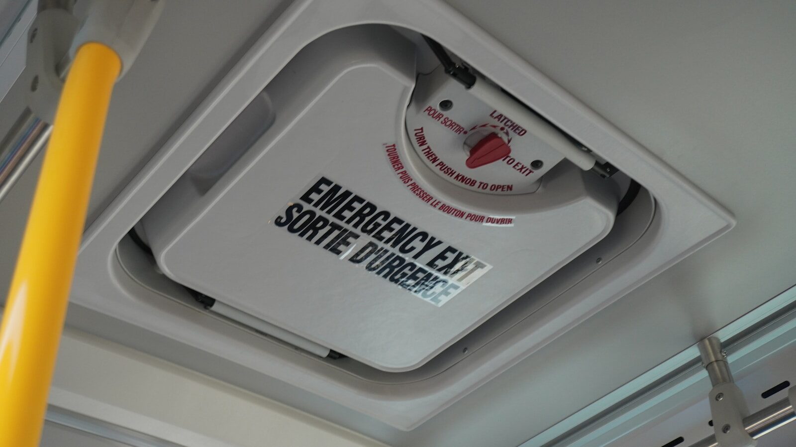 an emergency exit sign mounted to the ceiling of a bus